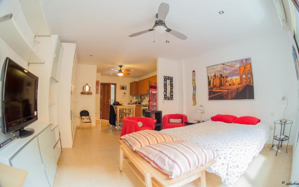 a bedroom with a bed and a flat screen tv at Apartamento La Higuera in Las Lagunas
