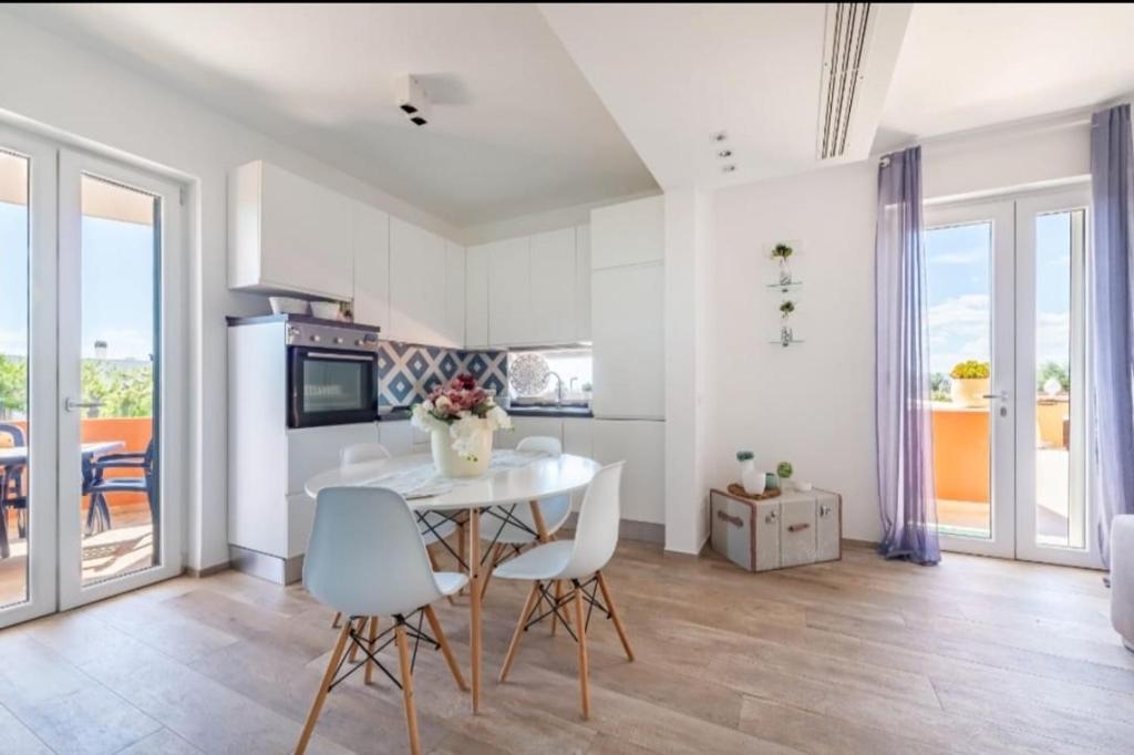 una cucina con un tavolo e sedie in una stanza di Maison Costa del Sol - Capitolo, Monopoli a Monopoli