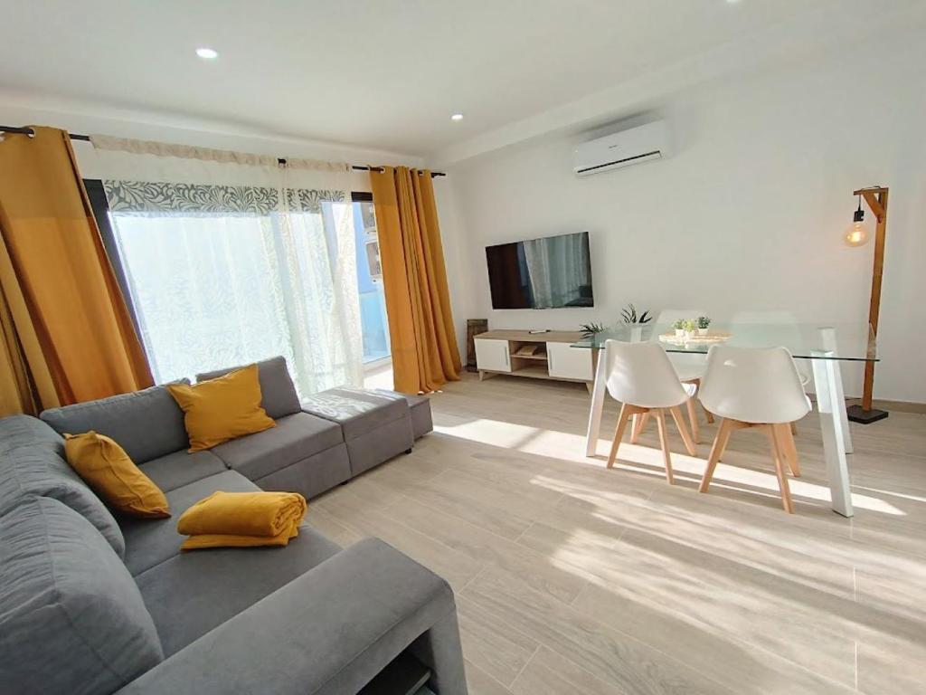 a living room with a gray couch and a table at Deluxe Arguineguin Beach in Arguineguín