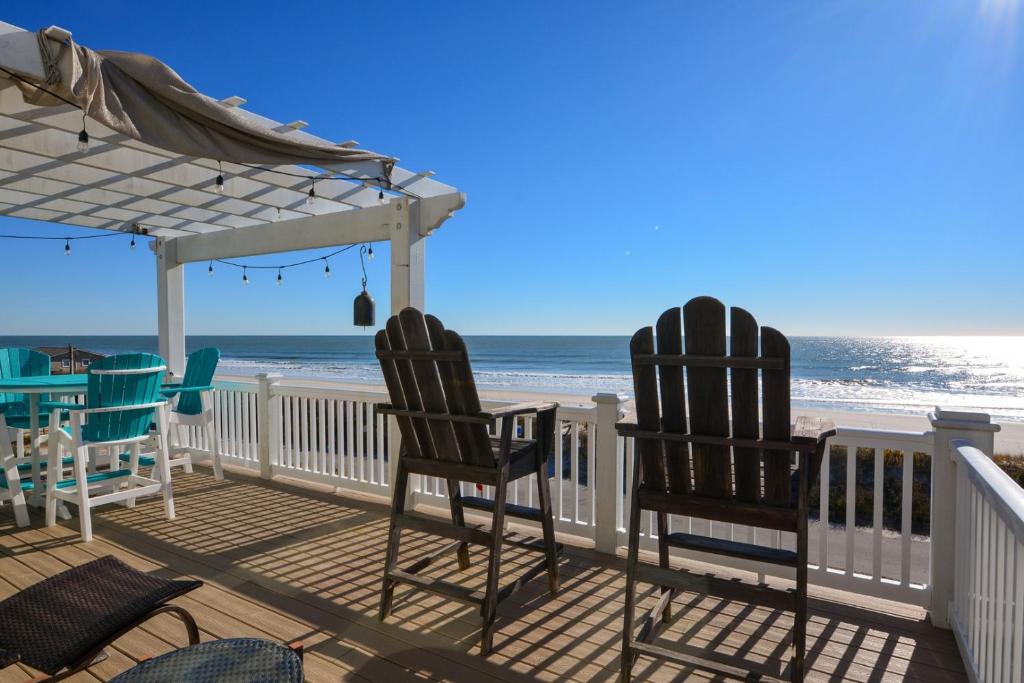 eine Terrasse mit Stühlen und Strandblick in der Unterkunft Sweet M'Ocean in Thomas Landing