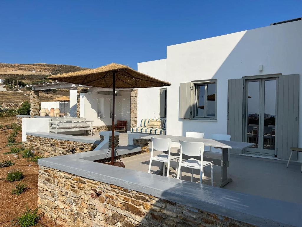a patio with a table and chairs and an umbrella at Comfortable apartment with sea view in Antiparos, 77 m² in Andiparos