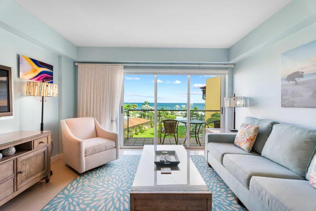 a living room with a couch and a table at Beachfront - Emerald View 2BR condo - P416 in Palm-Eagle Beach