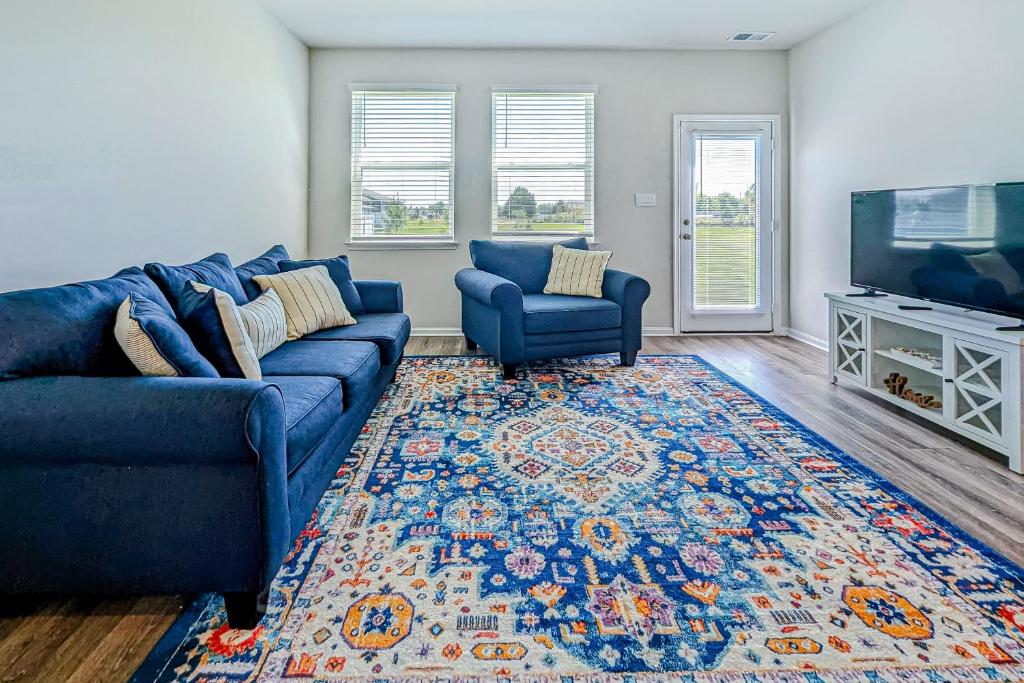 a living room with a blue couch and a tv at Millville by the Sea --- 35013 Sunfish Ln in Millville