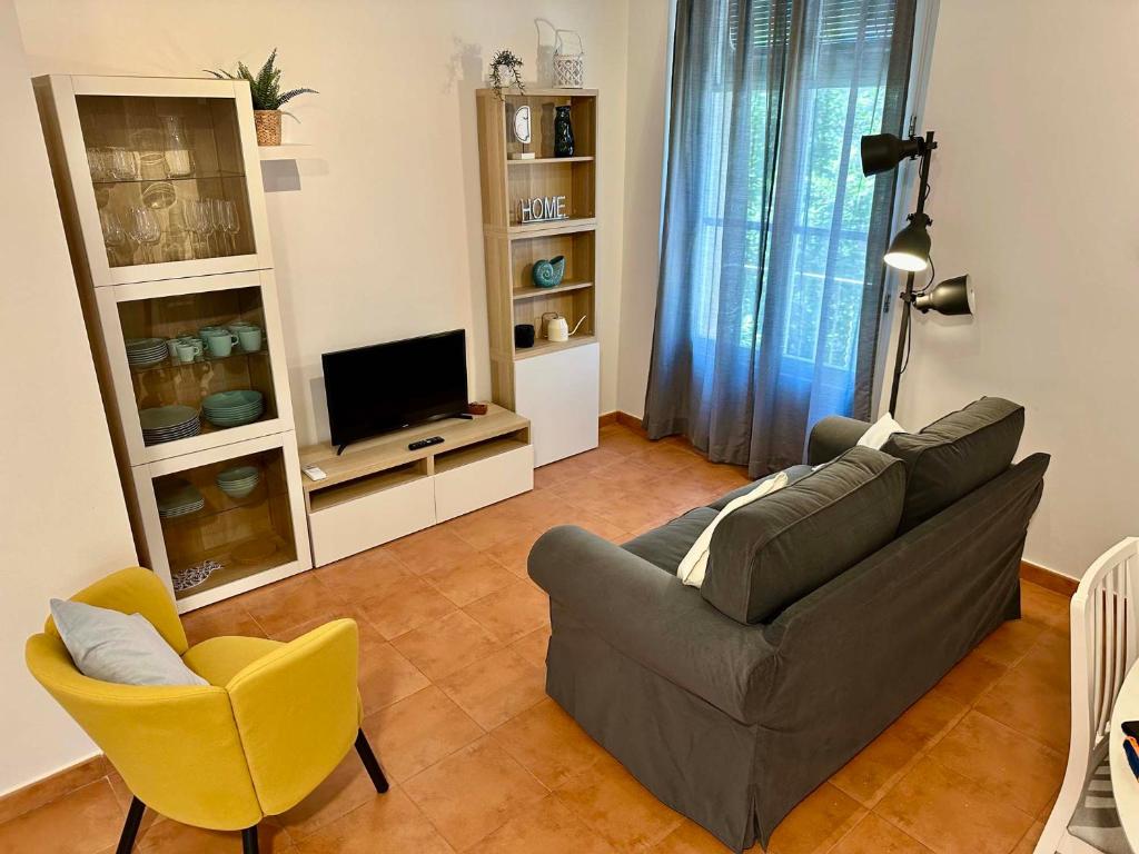 a living room with a couch and a chair and a television at Apartamento St Agustí - Centric in Mataró