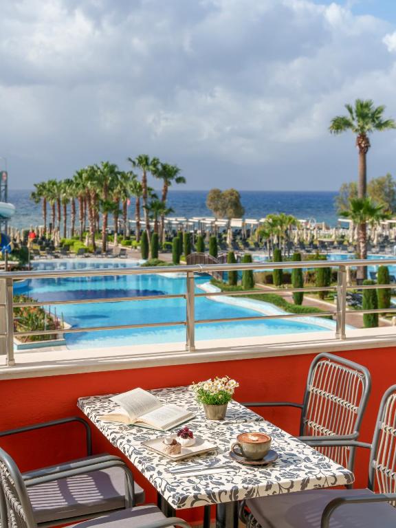 a table with a plate of food next to a pool at Liberty Kuşadası in Kusadası