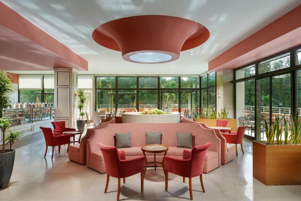 a lobby with a pink couch and chairs at Liberty Kuşadası in Kusadası