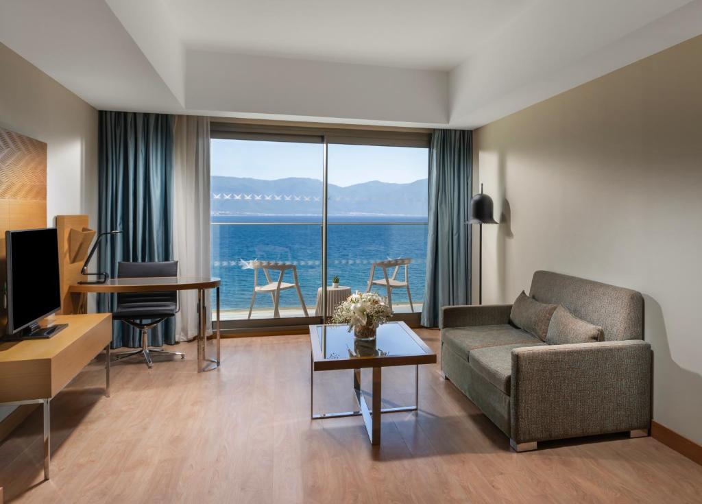 a living room with a couch and a view of the ocean at Liberty Kuşadası in Kusadası