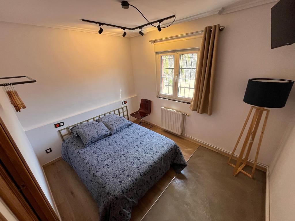 Un dormitorio con una cama y una ventana. en Lotila Flats Rio Caudal, en Figueredo