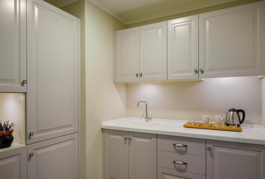 a kitchen with white cabinets and a sink at Liberty Kuşadası in Kusadası