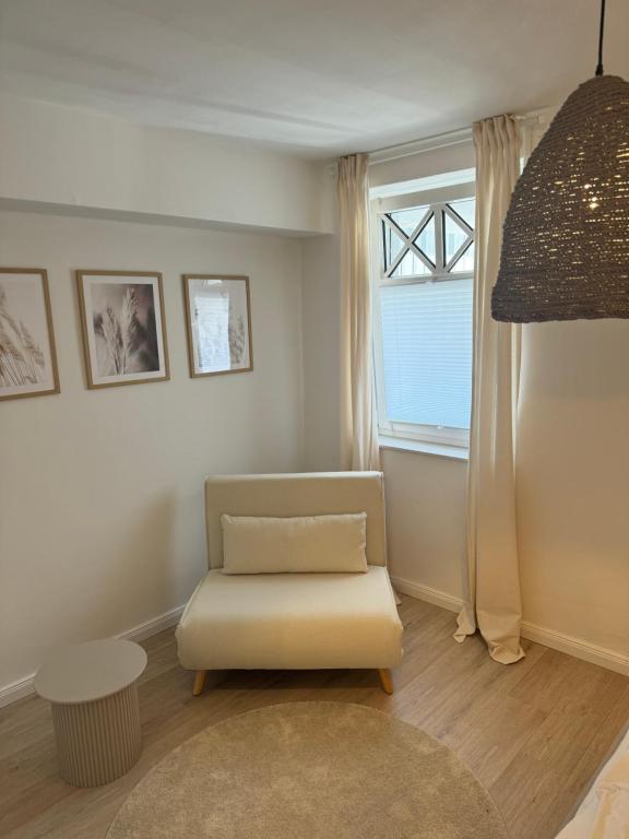 a living room with a chair and a window at 2,5 Zimmer Ferienwohnung Fehmarn mit eigenem Parkplatz in Fehmarn