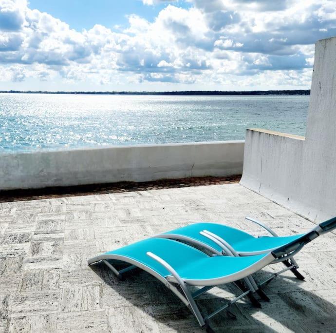 une chaise longue bleue au bord de l'eau dans l'établissement Studio les pieds dans l'eau et Parking, à Concarneau