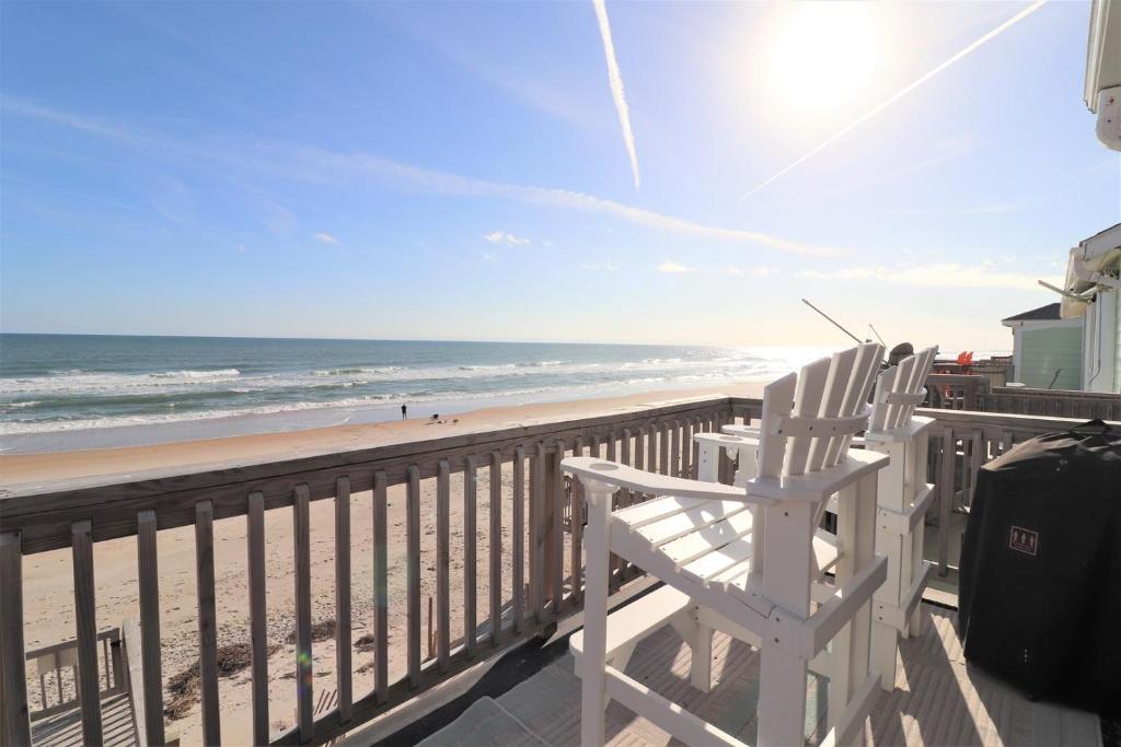 two chairs sitting on a balcony overlooking the beach at On Slow Time in West Onslow Beach
