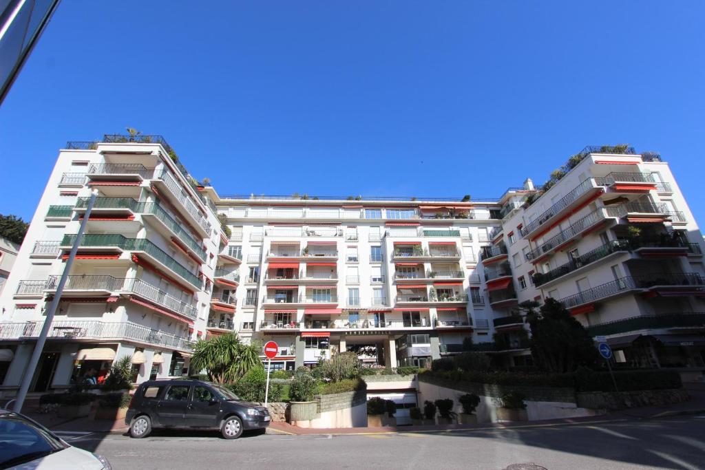 un grand immeuble avec une voiture garée devant dans l'établissement Appartements Cannes Centre : Rond Point Duboys d'Angers, à Cannes