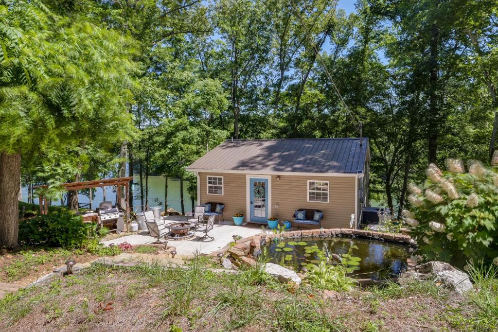 une petite maison avec un étang dans la cour dans l'établissement Riverfront Cottage Near Rock Island State Park, à Doyle