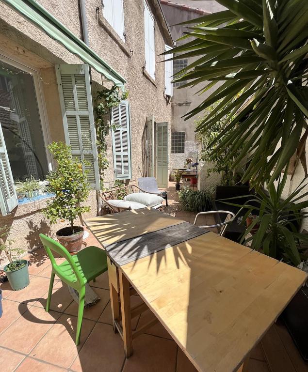 une table et des chaises en bois sur une terrasse dans l'établissement Appartement centre ville avec Patio, à Marseille