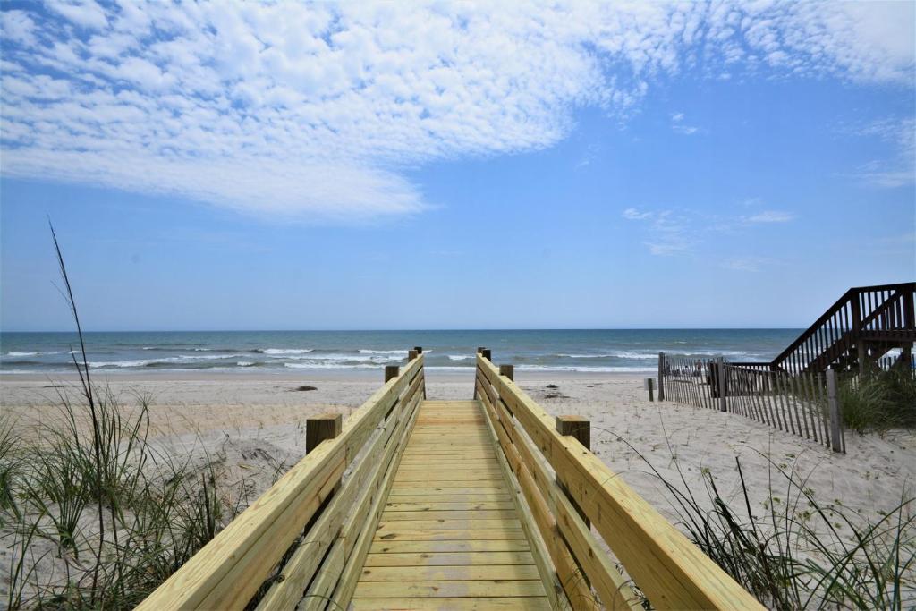 einen Holzweg zum Strand mit dem Meer in der Unterkunft Almost Heaven North in North Topsail Beach
