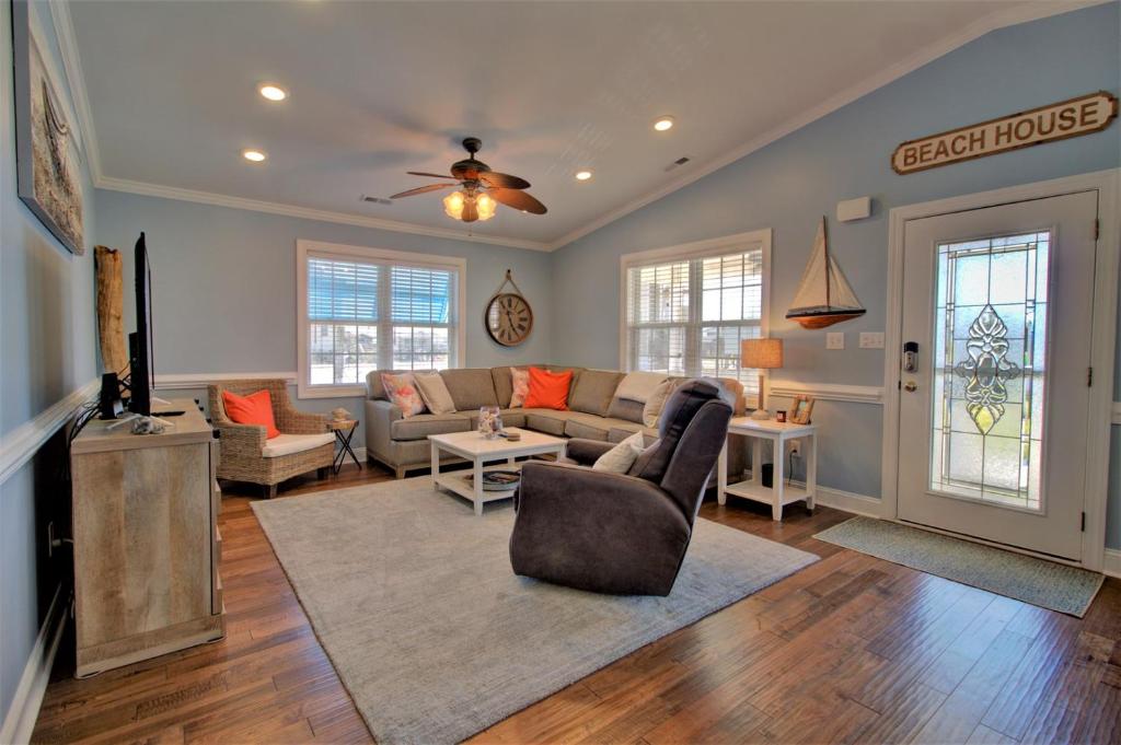 un soggiorno con un divano e una TV di Beach Therapy a Surf City