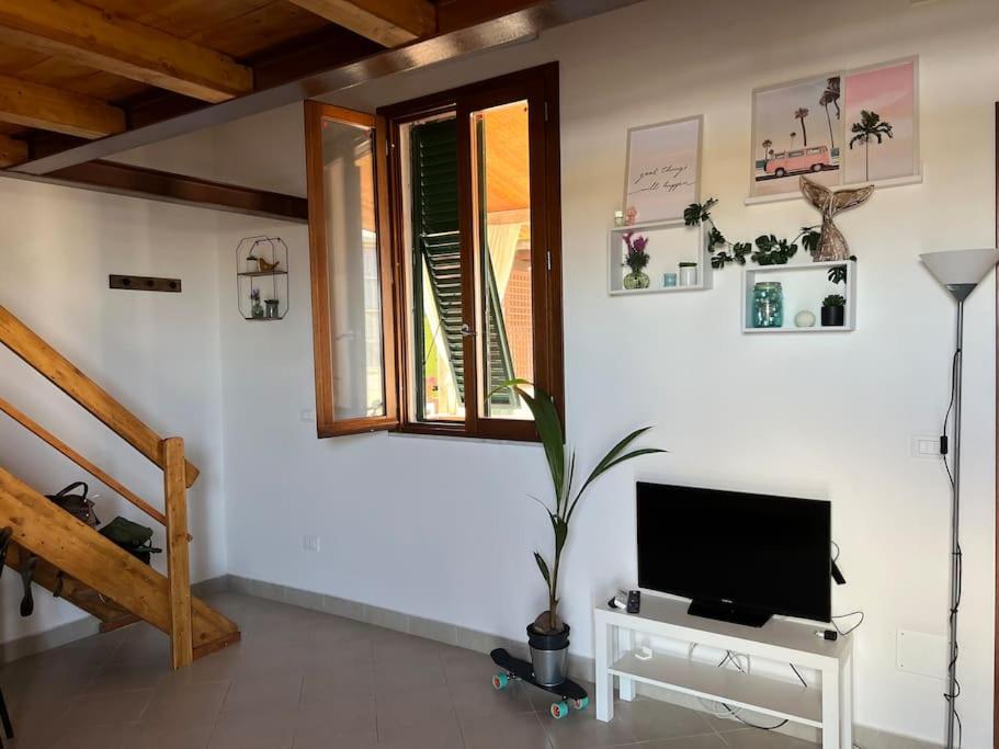 a living room with a television on a white wall at Casa Ondea in Marina di Pisa