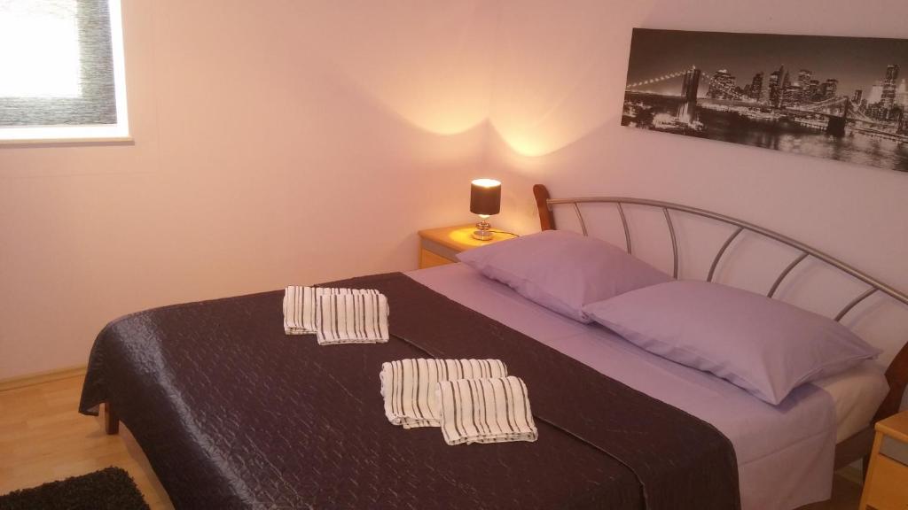 a bedroom with a bed with purple sheets and a lamp at Apartments Roncevic in Zadar