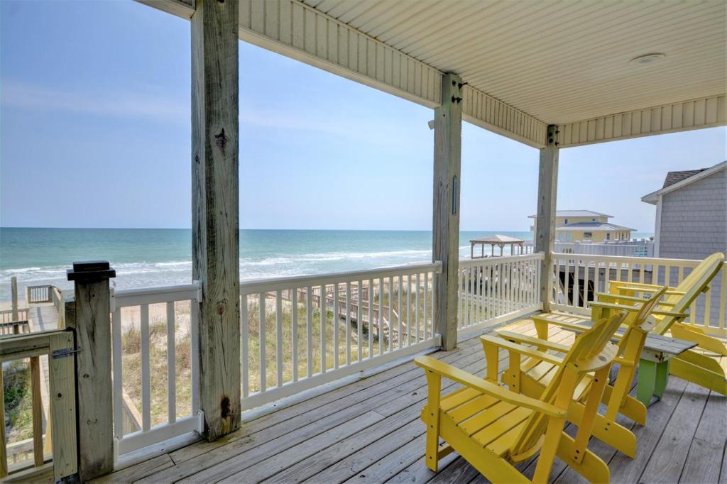 a porch with two yellow chairs and the ocean at Just Chill'n in North Topsail Beach