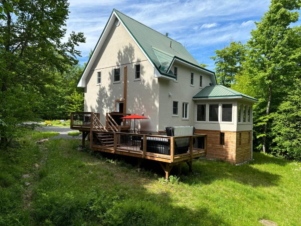 a house with a large deck in the yard at A Superior Experience - Tremblant N - hot tub and gym in Lac-Superieur