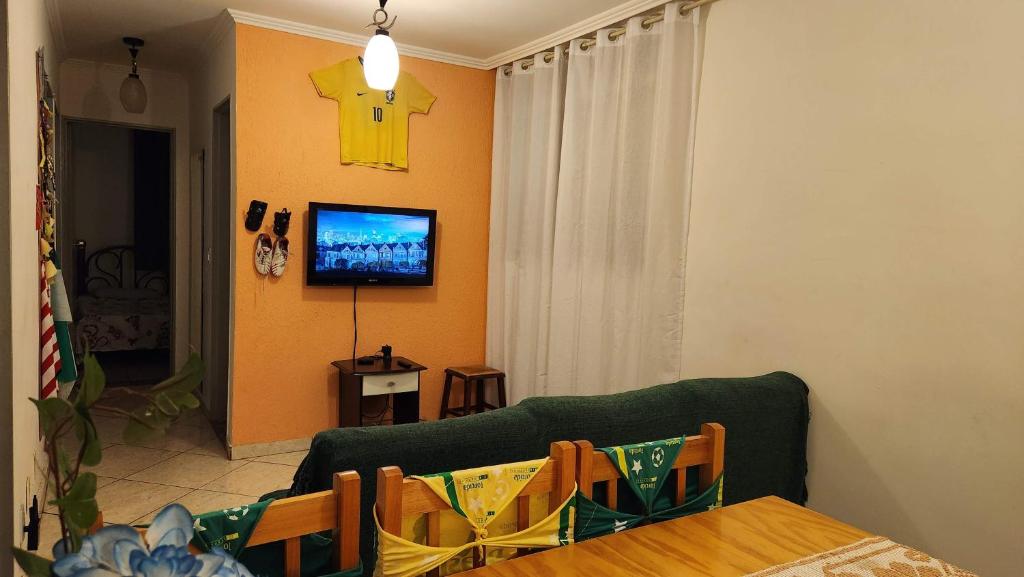 a living room with a green couch and a television at AP 3 quartos -2min da ARENA MRV e Expominas- BH in Belo Horizonte