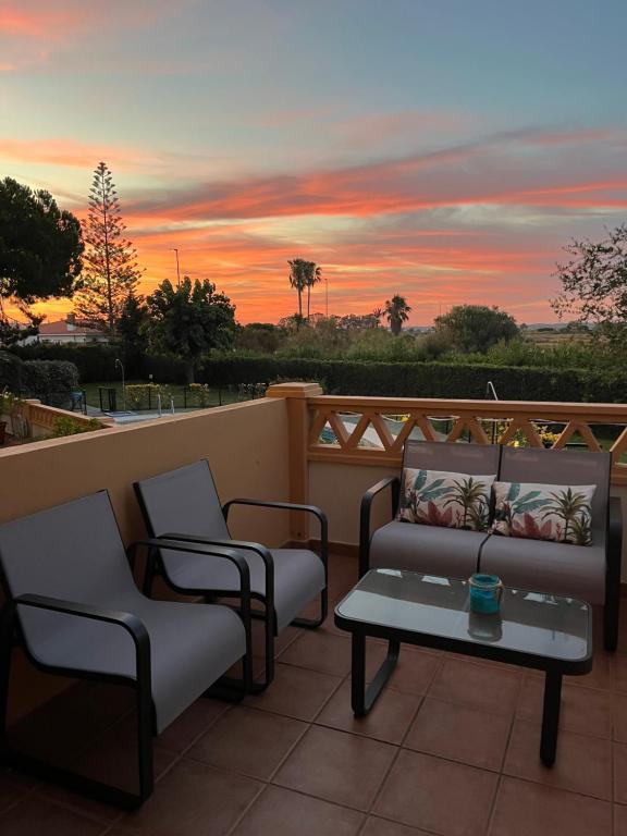 a patio with a couch and chairs and a table at El Paraíso de Isla Canela in Isla Canela