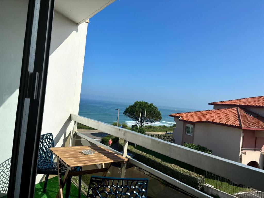 un balcon avec une table et des chaises et l'océan dans l'établissement Studio vue mer Nouveau!, à Anglet