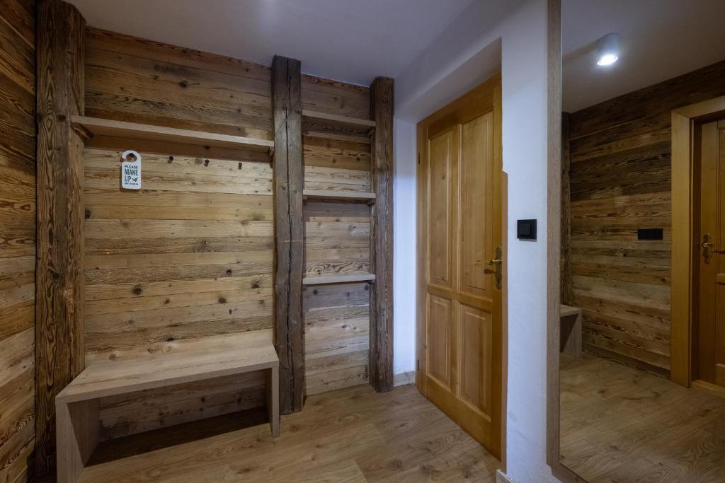 Zimmer mit Holzwänden und Holztür in der Unterkunft Hotel Olympie in Špindlerův Mlýn