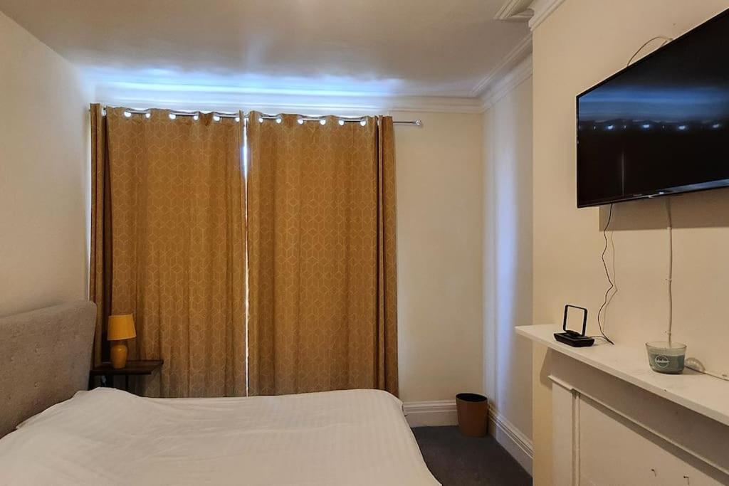 KentにあるOne Bed Comfort Studio Apartmentのベッドルーム1室(ベッド1台、テレビ付きシャワー付)