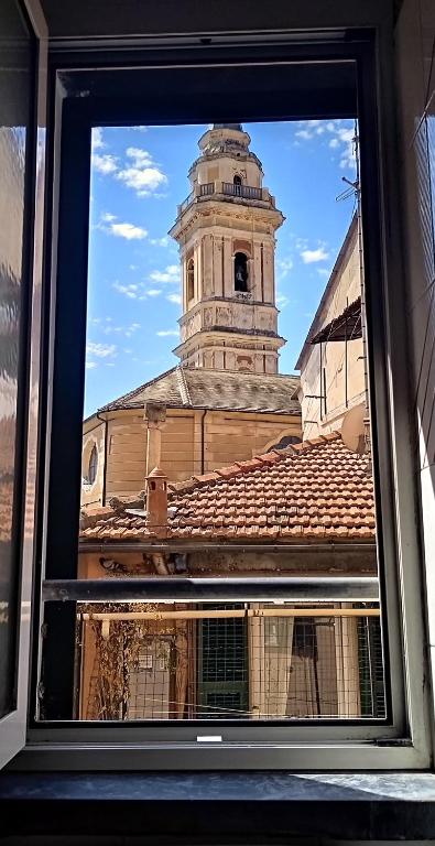 a window view of a building with a clock tower at I Mattoni Rossi in Imperia