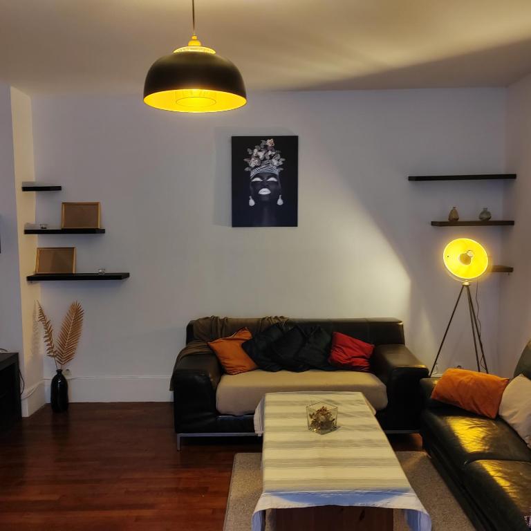 un salon avec un canapé et une table dans l'établissement Le bonheur Pantinois, à Pantin