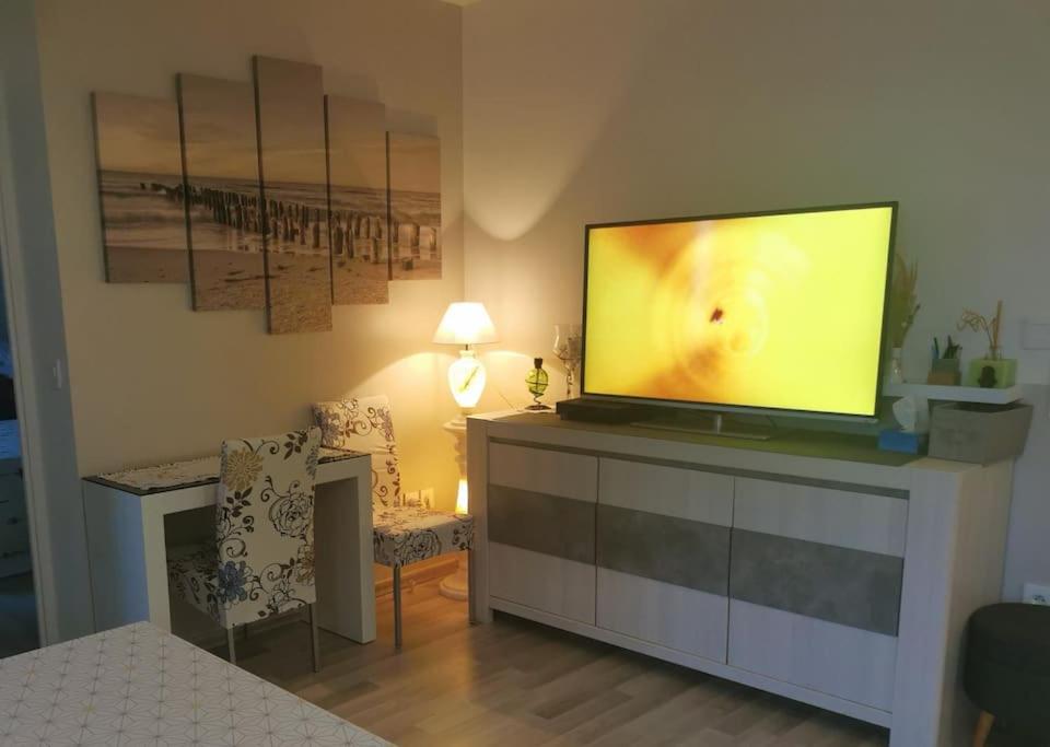 - un salon avec une commode et une télévision à écran plat dans l'établissement Appart 42 m2 à 1 min de l'A13 conforme photos, place de parking gratuite, wifi, à Magnanville