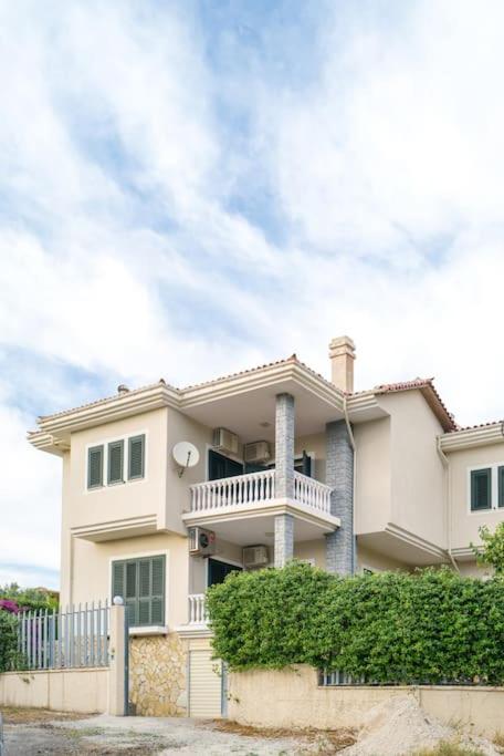 a large white house with a fence in front of it at Twin Villa Tragjas in Vlorë
