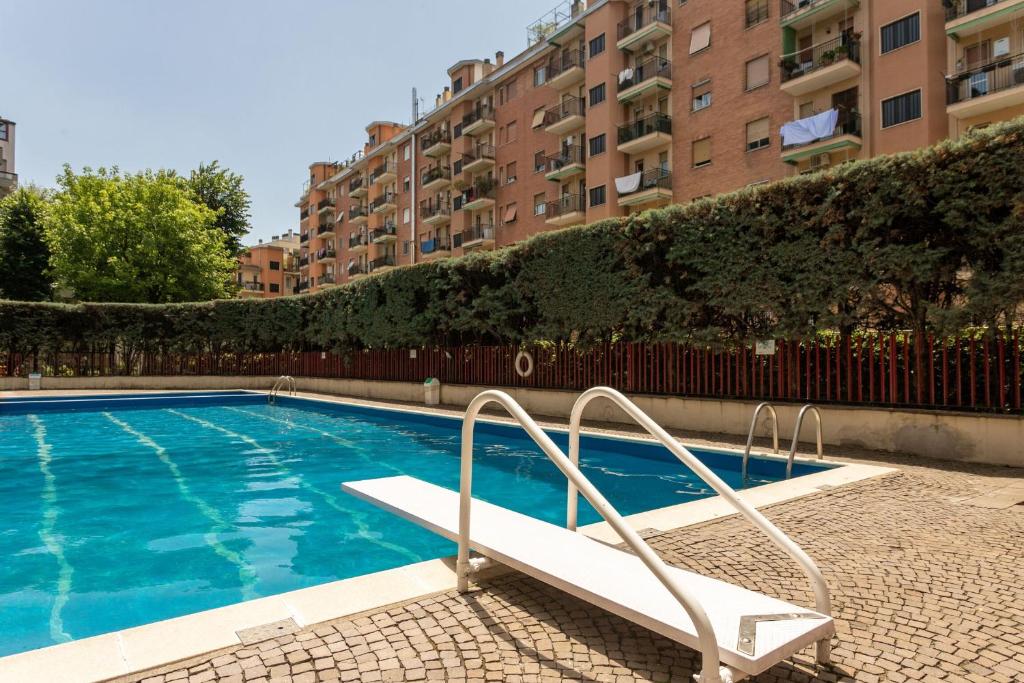 a swimming pool with a bench next to some buildings at Rucellai Studio With Shared Pool by Halldis in Milan