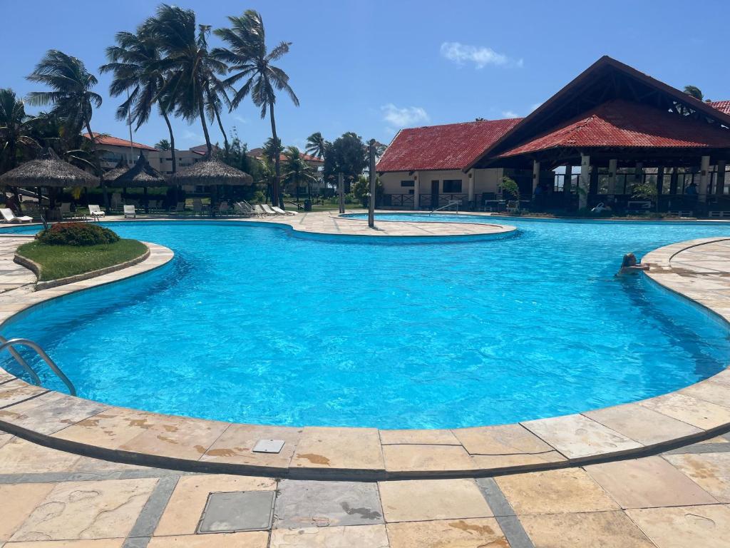 - une grande piscine d'eau bleue dans un complexe dans l'établissement Apartamento em Aquaville Resort, à Aquiraz