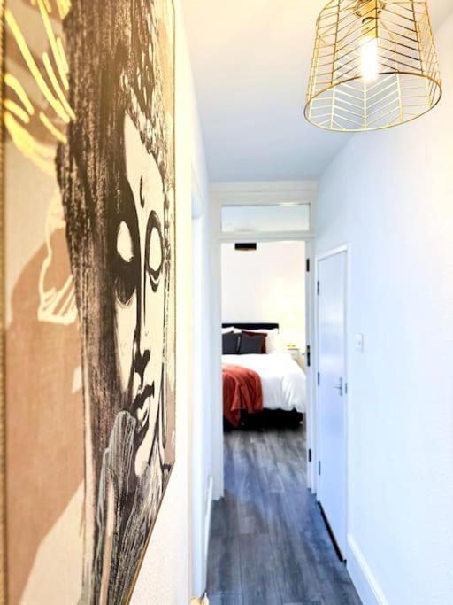 a bedroom with a bed and a painting on the wall at Stylish Westbrook Apartment in Kent