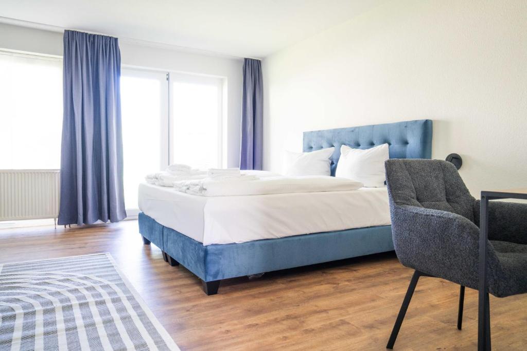 a bedroom with a large bed and a chair at Johouse Zingst Johouse Zimmer 19 in Zingst
