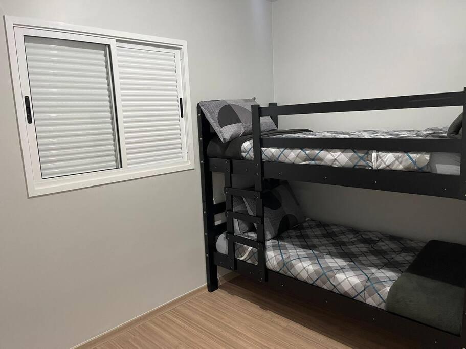 una habitación con dos literas y una ventana en Aconchego Familiar, en Londrina