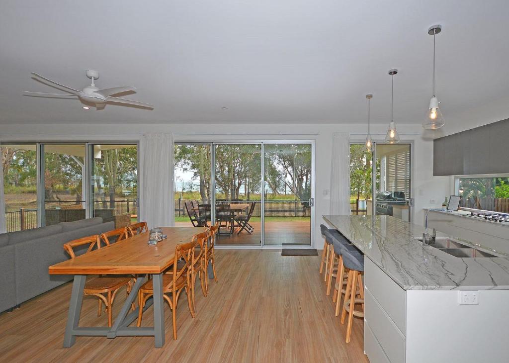 a kitchen and dining room with a wooden table and chairs at Beachside - Burrum Heads- Beachfront - 3BR- Wifi in Burrum Heads
