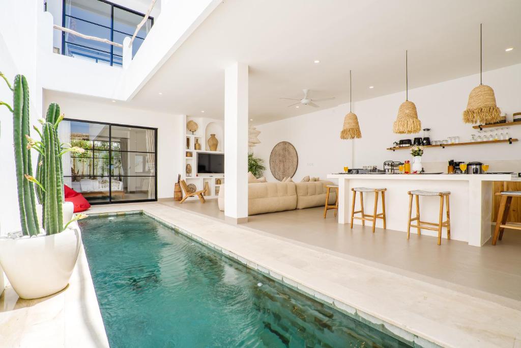 a living room and kitchen with a swimming pool in a house at Villa Valentina - Luxury 2BR with Pool and Rooftop in Quiet Area of Canggu in Canggu