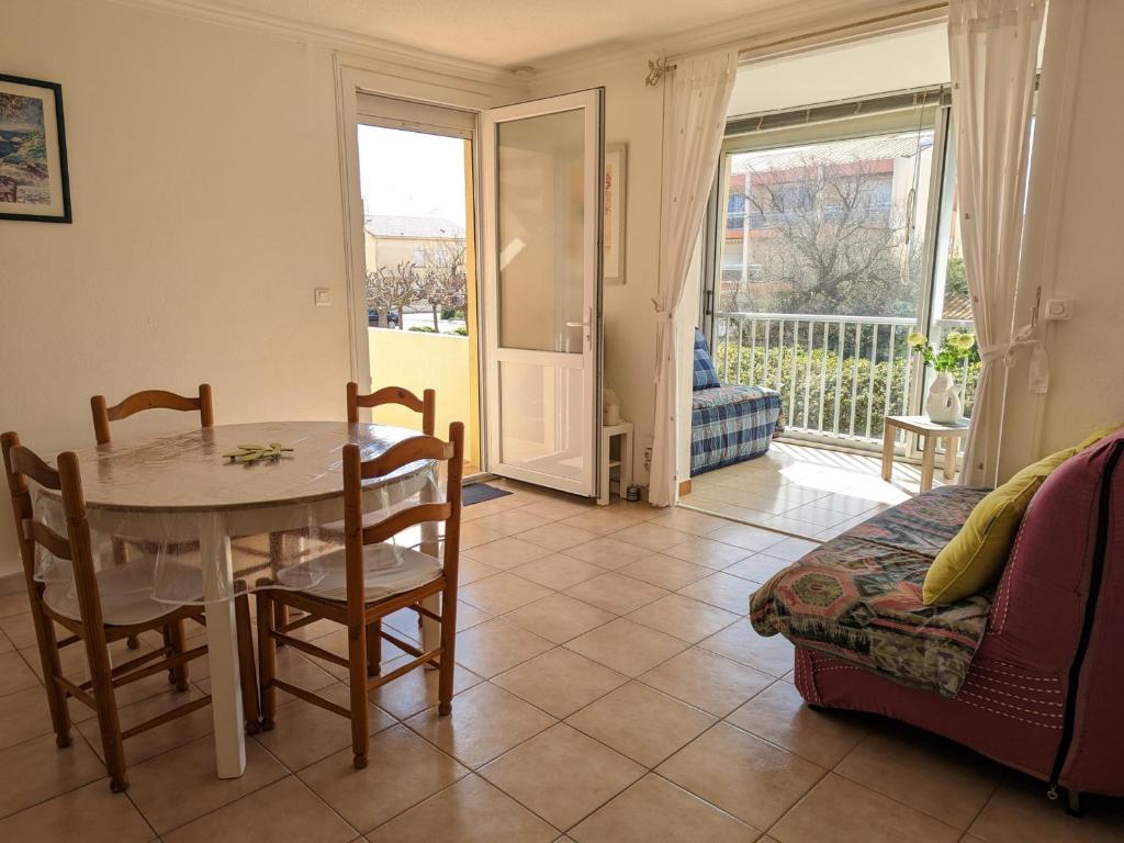 un salon avec une table et des chaises et un balcon dans l'établissement Appartement T2 lumineux 40m2, 4 personnes, 150m de la plage, bien équipé et proche loisirs - FR-1-797-18, à Port-la-Nouvelle