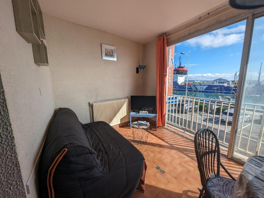 d'un salon avec un canapé et un balcon. dans l'établissement Appartement T4 proche plage et commerces, 80m2, 6 pers, lave-linge, TV - FR-1-797-23, à Port-la-Nouvelle