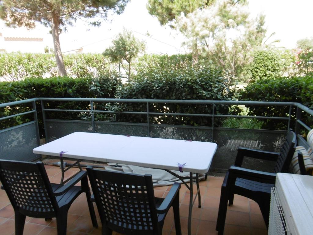 une table blanche et des chaises sur une terrasse dans l'établissement T3 Climatisé RDC avec Terrasse, Parking, Proche Activités - Port-la-Nouvelle - FR-1-797-30, à Port-la-Nouvelle