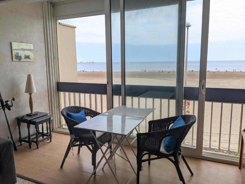 - une salle à manger avec une table et des chaises ainsi qu'une plage dans l'établissement T2 Climatisé 4 pers. avec Parking, Front de mer, Port-la-Nouvelle - FR-1-797-10, à Port-la-Nouvelle