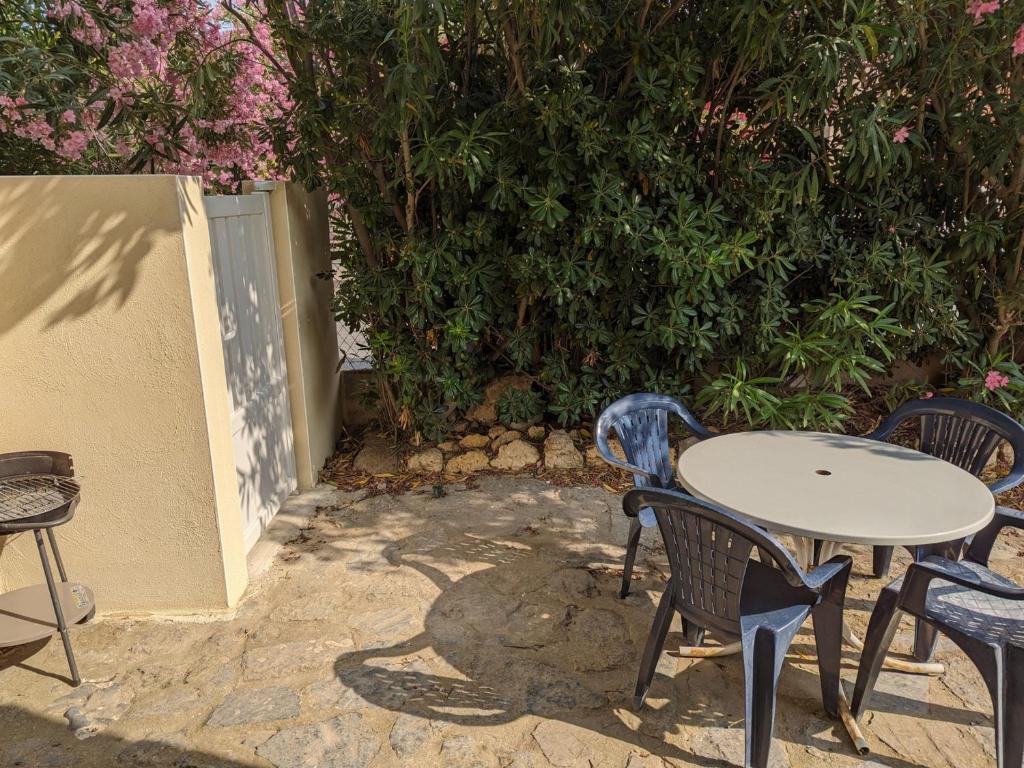 une table et des chaises assises sur une terrasse dans l'établissement Port-la-Nouvelle : T2 proche plage, terrasse, parking, clim, BBQ, lave-linge, 4 pers, classé 2* - FR-1-797-17, à Port-la-Nouvelle