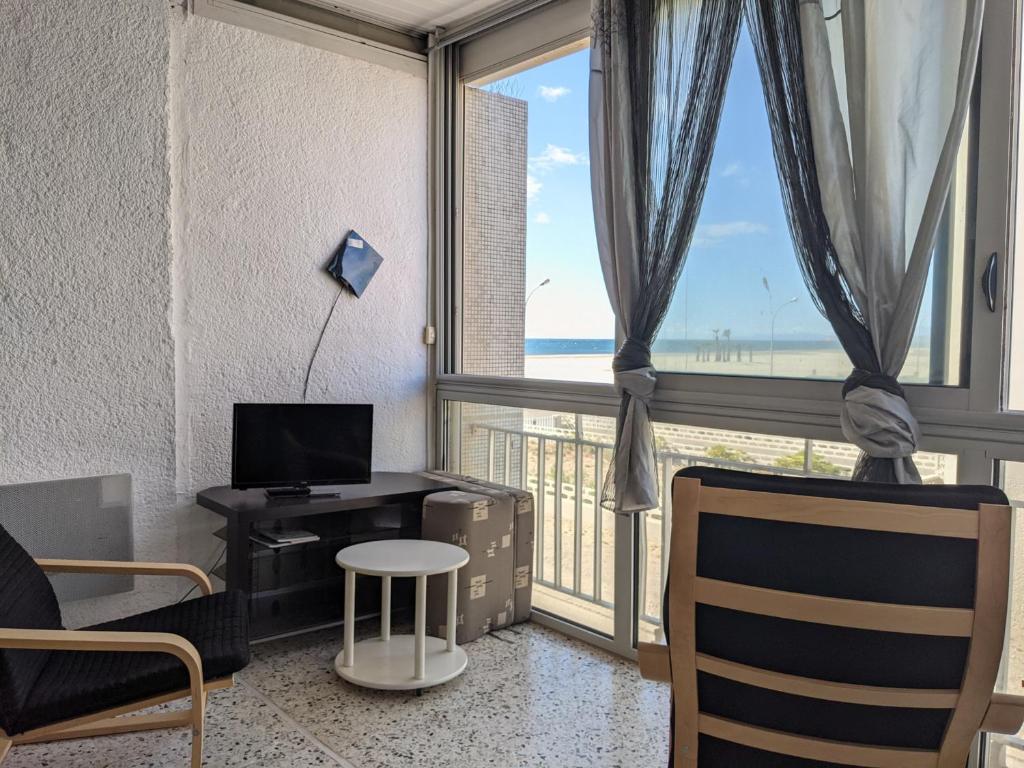 un salon avec une grande fenêtre avec vue sur l'océan dans l'établissement T2 Front de Mer Vu latérale, 4 pers, Parking, Proche plage et animations - FR-1-797-16, à Port-la-Nouvelle