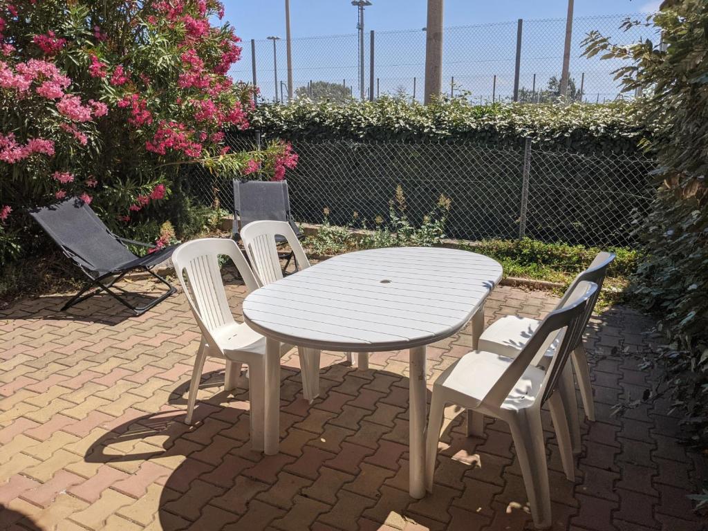 une table blanche et quatre chaises et une table et des chaises dans l'établissement Charmante Maison T2 Mezzanine avec Jardin et Parking, à 500m de la Plage - 6 Pers. - FR-1-797-46, à Port-la-Nouvelle