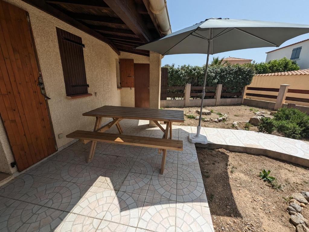 - une table de pique-nique avec un parasol sur la terrasse dans l'établissement Maison T2 avec Mezzanine, Cour et Parking – 5 Pers – Proche Plage et Commerces – Bon Prix - FR-1-797-49, à Port-la-Nouvelle