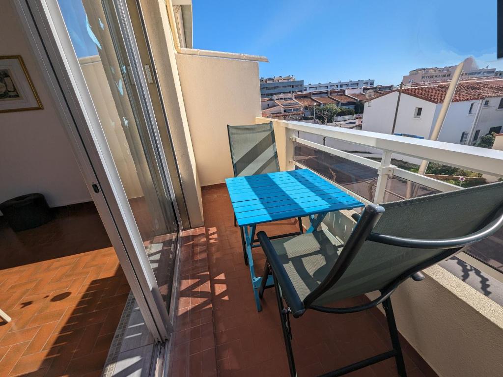 une table bleue et une chaise sur un balcon dans l'établissement Lumineux T2 à 100m de la plage avec balcons – Idéal 4 pers – Proche centre commercial et animations - FR-1-797-51, à Port-la-Nouvelle